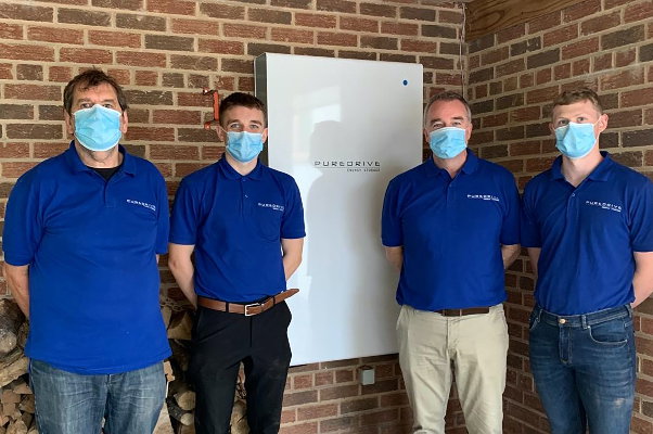 Four members of the Puredrive team smile after completing a Pure-Storage II AC Battery installation