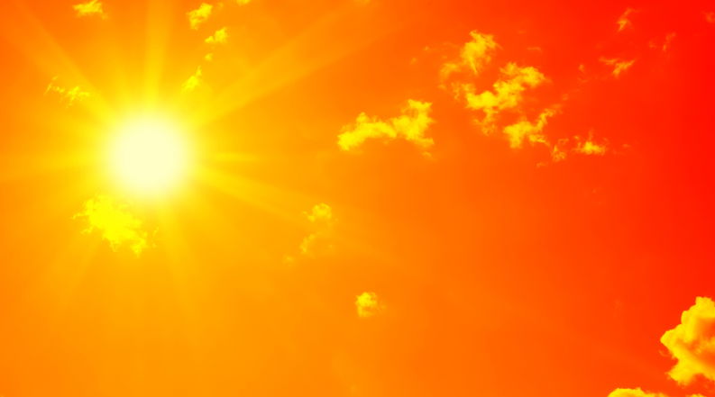 Bright sun with beautiful beams in the sky with clouds