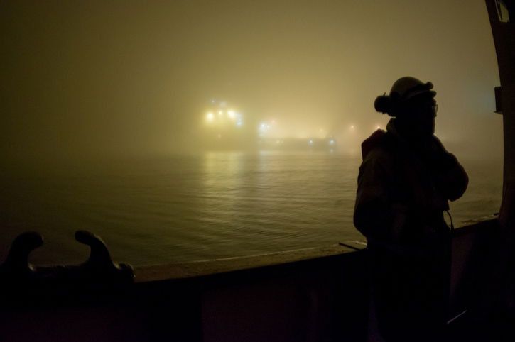 North Sea oil rig worker at sea on a foggy dark night