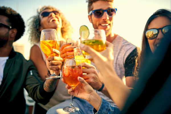 Shot of a group of young friends hanging out and having drinks together outdoors