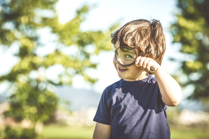 Toddler looking through a magnifying glass