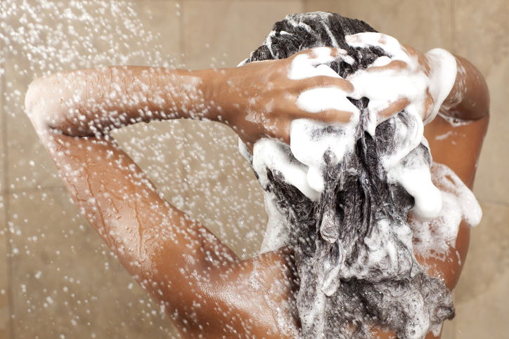 Woman washing her hair with shampoo